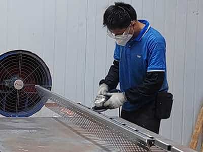 Grinding treatment on a metal storage shelf, enhancing surface smoothness and preparing the structure for finishing in custom fabrication.